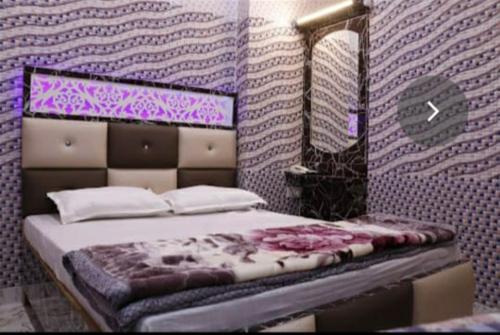 1 dormitorio con 1 cama con pared morada en Hotel Pari, en Jalandhar
