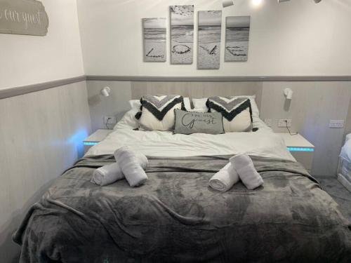 a bedroom with a large bed with two pillows at 5 bed, 5 bath New refurbishment for 2024. Sleeps 16, 60 yds beach & harbour in Weymouth