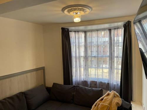 a living room with a couch in front of a window at 5 bed, 5 bath New refurbishment for 2024. Sleeps 16, 60 yds beach & harbour in Weymouth