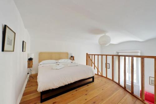 una camera con un letto su un pavimento in legno di Super appartamento nel cuore del Pigneto a Roma