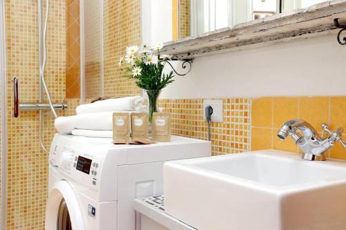 una lavanderia con lavatrice e lavandino di Super appartamento nel cuore del Pigneto a Roma