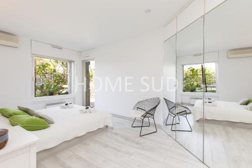 a white room with two beds and two chairs at HSUD0085-Sansovino in Cannes