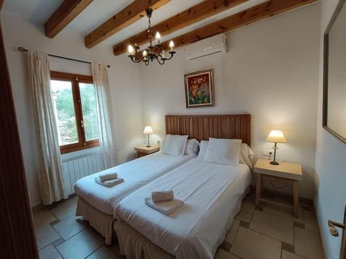 een slaapkamer met een groot wit bed en een raam bij Finca rural s'Estepa in Palma de Mallorca