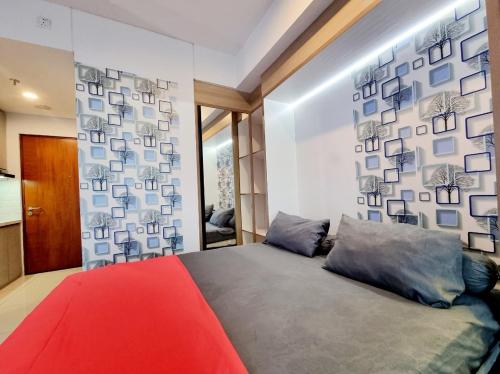 een slaapkamer met een bed en een muur met foto's bij Apt Roseville Soho and suite studio w/ wifi & pool in Dadap