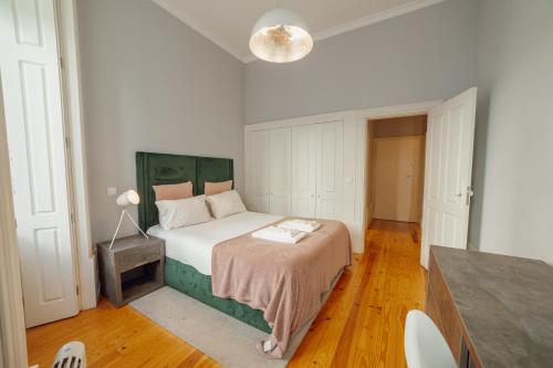 1 dormitorio con 1 cama con cabecero verde en Formosa Deluxe by Hosty en Oporto