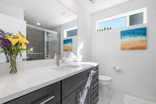 Un baño blanco con lavabo e inodoro. en New Home!!! Minutes from Downtown, Duke & Hospital, en Durham