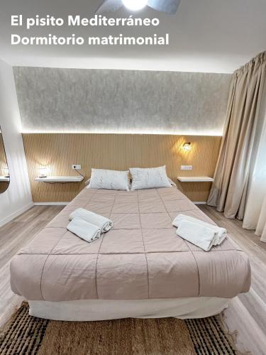 a bedroom with a large bed with two pillows at El pisito mediterráneo in Melilla