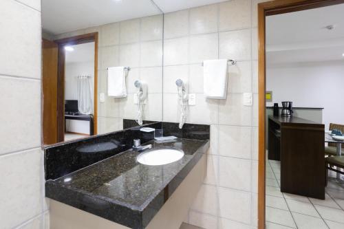 a bathroom with a sink and a phone at Flat Metropoles Ilha do Leite by Easy Home in Recife