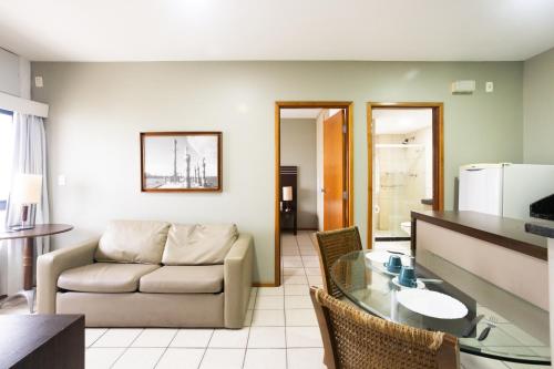a living room with a couch and a glass table at Flat Metropoles Ilha do Leite by Easy Home in Recife