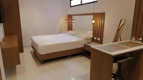 1 dormitorio con cama, escritorio y espejo en NOVAPARK HOTEL, en Guayaquil