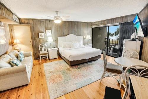 um quarto com uma cama e uma sala de estar em 2nd Floor Oceanfront King Room Tower em Pawleys Island