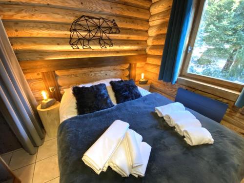 1 dormitorio con 1 cama azul en una cabaña de madera en L'OURS NOIR Chalet en rondins, en La Bresse