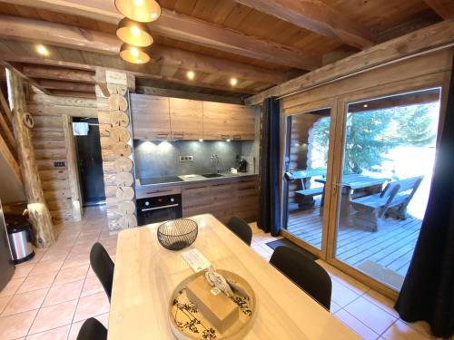 une cuisine et une salle à manger avec une table et des chaises dans l'établissement L'OURS NOIR Chalet en rondins, à La Bresse