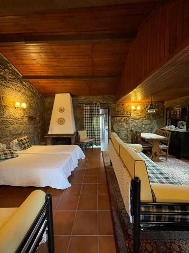 a bedroom with two beds and a stone wall at Casa dos Limões in Arcos de Valdevez