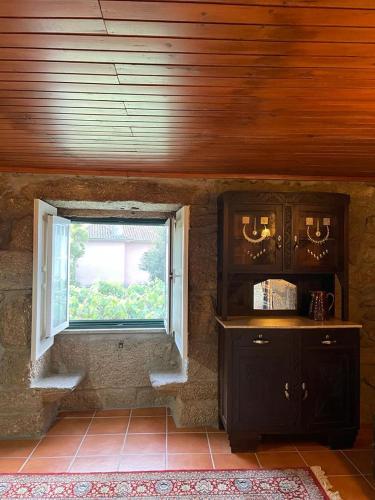 a room with a window and a table and a counter at Casa dos Limões in Arcos de Valdevez
