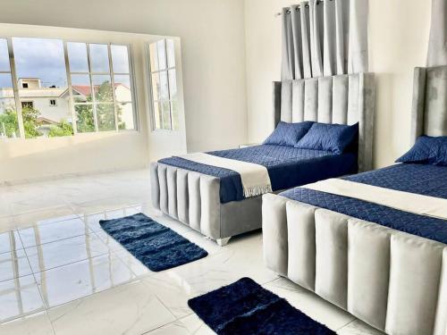 two beds in a room with blue rugs at Villa Familiar con Piscina cerca Av Ecológica in La Ureña