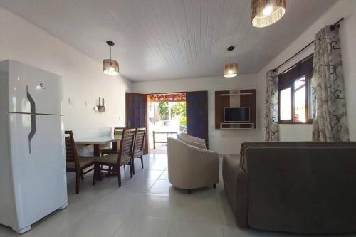 a kitchen and living room with a refrigerator and a table at Lady Sea Praia do Patacho in Pôrto de Pedras