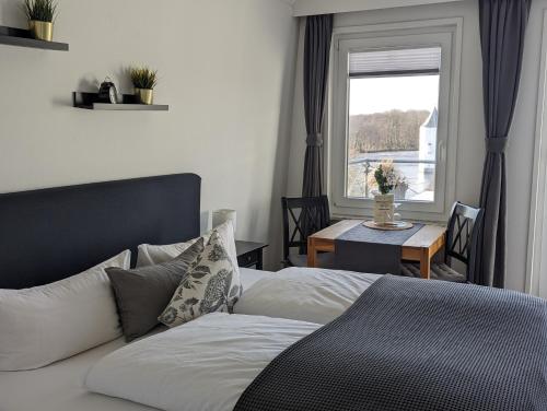 1 dormitorio con 1 cama y 1 mesa con ventana en Hotel am Wasserschloss Glücksburg, en Glücksburg