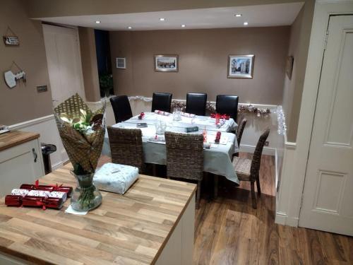 a dining room with a white table and chairs at 4 bedroom / 2 bathroom house in desirable area. in Dundee