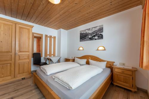1 dormitorio con cama y techo de madera en Fernerblick Apartments en Tux