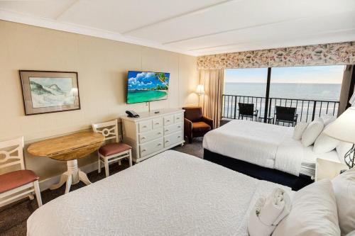 a hotel room with two beds and a desk at Beachy 5th Floor Oceanfront Room in Pawleys Island