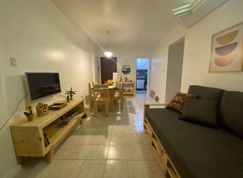 - un salon avec un canapé, une télévision et une table dans l'établissement Aconchegante e bem localizado, à Salvador