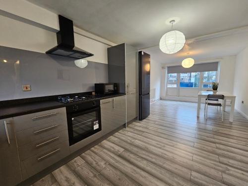 a kitchen with a stove and a dining room at London Mile End Rooms in London