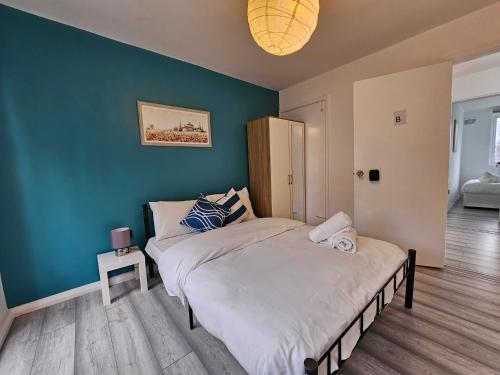 a bedroom with a bed and a green wall at London Mile End Rooms in London