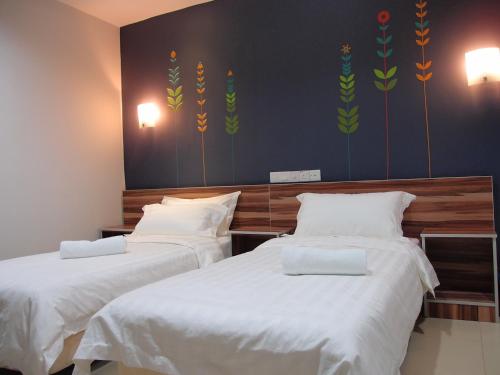 a bedroom with two beds with white sheets at One Avenue Hotel Balakong in Seri Kembangan