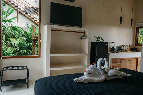 a bedroom with a bed with two swans on it at Holbox Deluxe Apartments in Holbox Island