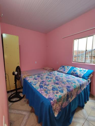 um quarto com uma cama num quarto com paredes cor-de-rosa em Recanto dunas em Tutóia