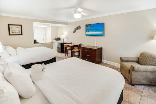 ein Hotelzimmer mit 2 Betten, einem Stuhl und einem Tisch in der Unterkunft Ravishing Oceanview Room 2nd Flr in Pawleys Island