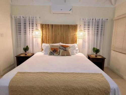 a bedroom with a large white bed with two zebra pillows at The Gardenia Compound - Ocho Rios Area in Richmond
