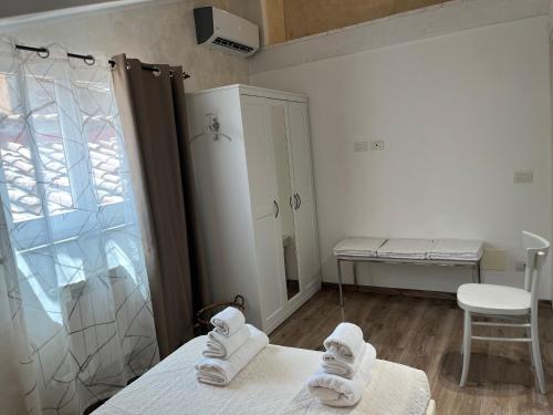 DOMUS TUSCIA APARTMENTS San Faustino guesthouse في فِتيربو: غرفة بها منشفتين بيض على سرير