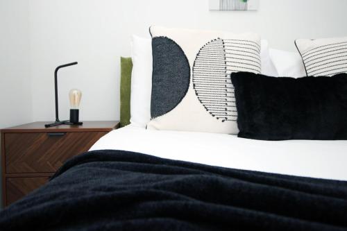 a bedroom with a bed with black and white pillows at Church Road Cardiff FREE parking in Cardiff