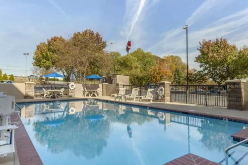 une grande piscine avec des chaises et des tables dans l'établissement Comfort Inn Greensboro - Kernersville, à Greensboro