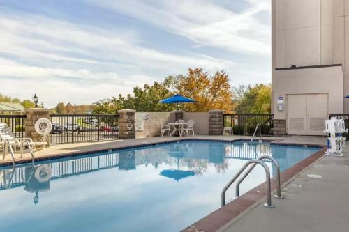 een zwembad met stoelen en een tafel en parasol bij Comfort Inn Greensboro - Kernersville in Greensboro