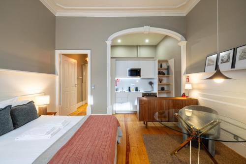 - une chambre avec un lit et une table en verre dans l'établissement Casa do Ofício - Livreiro, à Porto