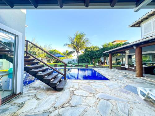 une piscine avec un escalier à côté d'une maison dans l'établissement Pousada Mansão Triplex Jolly, à Búzios