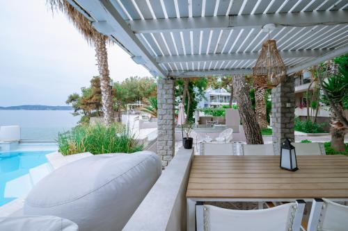 a patio with a table and chairs and a pool at Ktima Papaoikonomou in Potos