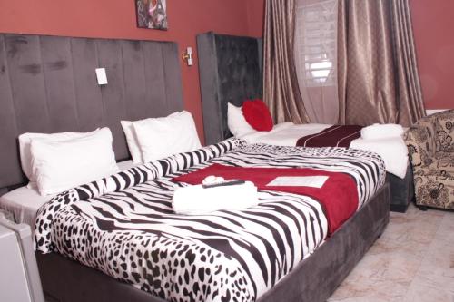 two beds in a hotel room with a zebra blanket at Gold Crown International Hotel in Johannesburg