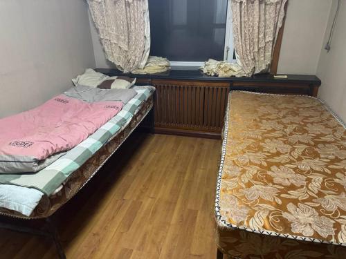 two beds in a room with a window and a mattress at 九九煮熟 in Macau