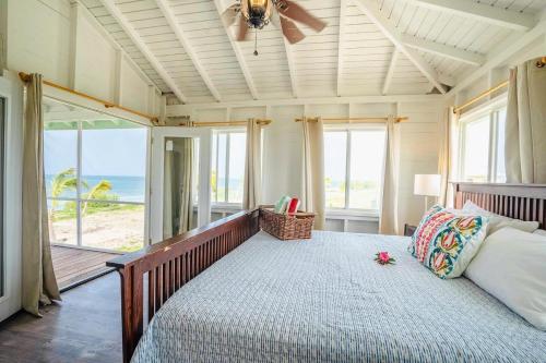 a bedroom with a bed with a view of the ocean at Barbuda Cottages in Codrington Village