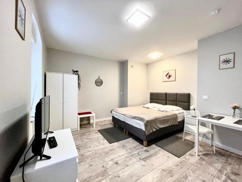 niewielka sypialnia z łóżkiem i biurkiem w obiekcie Wąska 5 Apartamenty we Wrocławiu