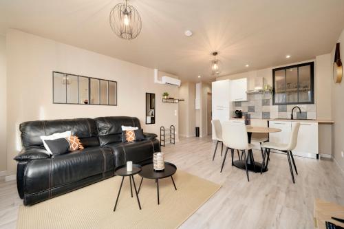 un salon avec un canapé en cuir noir et une table dans l'établissement L'Elégance du centre - Nancy Gare Congrès - PARKING - T3, à Nancy