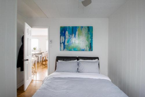 a bedroom with a bed and a painting on the wall at Repère d'Eastman (accès au lac/foyer/randonnée) in Eastman