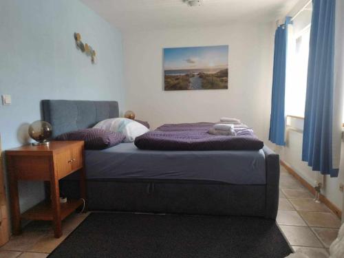 Schlafzimmer mit einem Bett, einem Tisch und einem Fenster in der Unterkunft Bjælkehytten in Handewitt