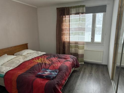 um quarto com uma cama e uma janela em Saunallinen iso omakotitalo em Kotka