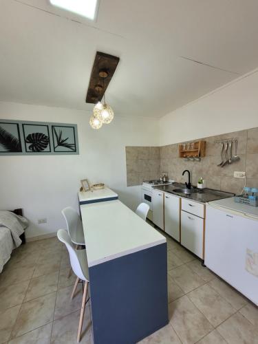 a kitchen with white cabinets and a sink and a counter at Cabañas "El Ancla" in Puerto San Julián