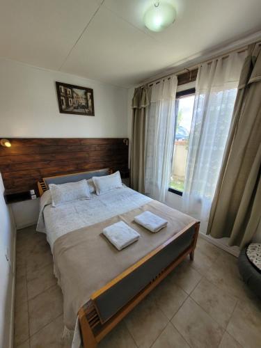 ein Schlafzimmer mit einem großen Bett mit zwei Handtüchern darauf in der Unterkunft Cabañas "El Ancla" in Puerto San Julian